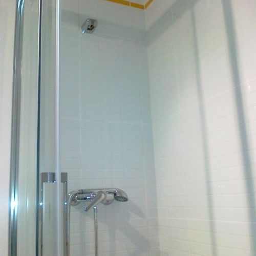 Cambio de bañera por plato. En esta ocasión se sustituyó el alicatado de  ambas paredes de la zona de la ducha, colocando azulejo tipo mosaico en blanco de Mallol. La mampara es de kassandra.