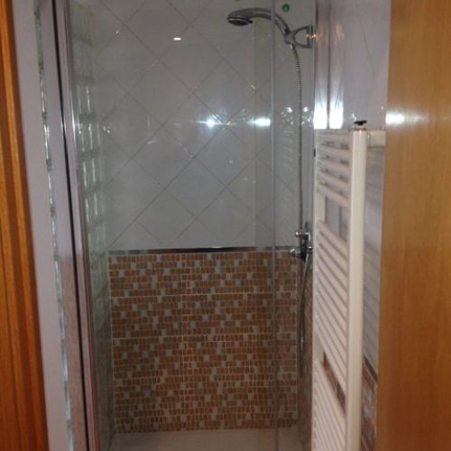 Sustitución del antiguo plato de ducha y reposición del zócalo del baño. Mampara de Kassandra.